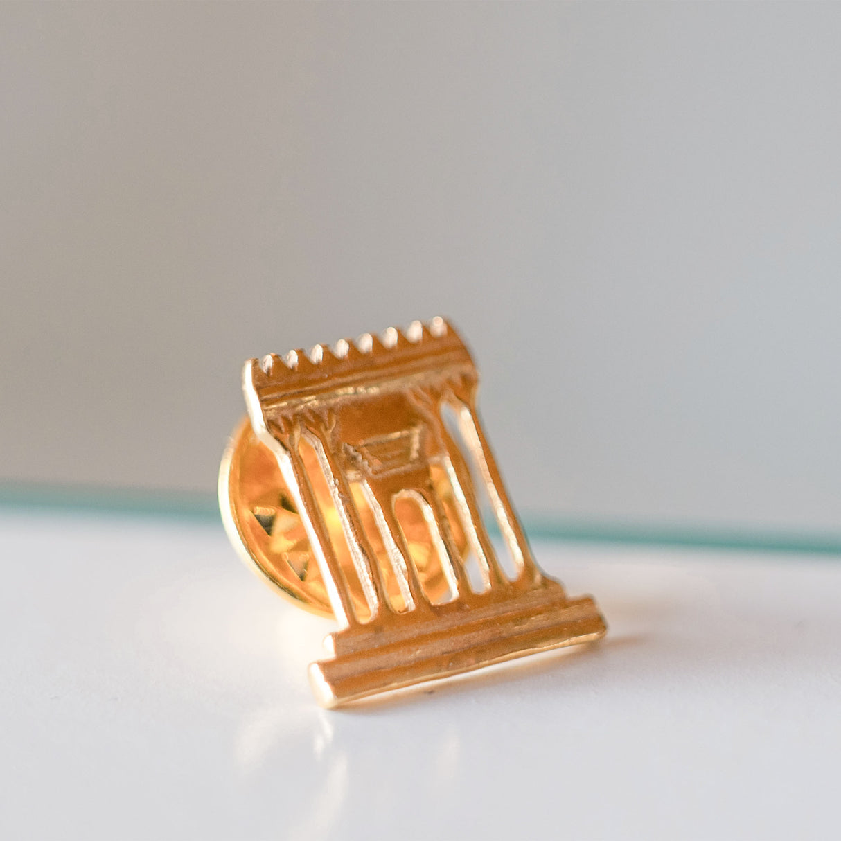 Gold architectural design on a white surface with a light gray background